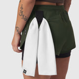 Tetra-Lite® Liner Short in olive worn by model, back view with white towel