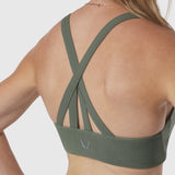 Sage green Lycra hybrid sports bra worn by model, back view showing cross-back strap design