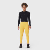 W059 Hybrid Belt-Pack Run Legging in amber yellow, worn with black long-sleeve top and black sneakers