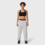 Model wearing black sports bra and grey joggers with black waistband detail, front view