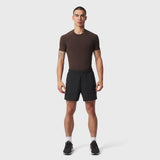LYCRA® ADAPTIV Baselayer Shortsleeve in dark brown worn with black shorts, front view