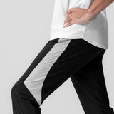 Black and white Tetra-Lite cuffed training jogger worn by model, side view