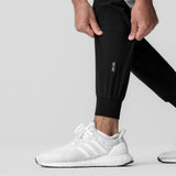 Black Tetra-Lite cuffed training jogger worn with white sneakers, side view