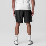 Towel Terry Relaxed Short in black, worn by model with white tee and white sneakers, back view