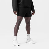 Black waffle knit sweat shorts worn with white socks and sneakers, front view