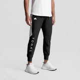 Black Tetra-Lite cuffed training jogger worn by model with white sneakers, front view