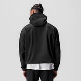 Black weather-ready anorak jacket worn by model, back view, with white shirt visible underneath