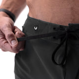 Black Revolutional® Board Short being adjusted at waist by model, detail view