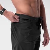 Black Revolutional® Board Short on model, side view with hand adjusting waistband