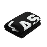 flatlay 0888. Sherpa Recovery Blanket in black with white logo, folded overhead view