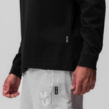 Tech Essential Relaxed Long Sleeve in black worn with grey joggers, detail view