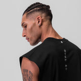 Black Tech Essential Rocker Cutoff worn by model in profile view, showing back design
