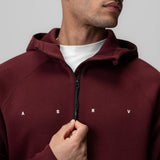 Dri-Core Zip Hoodie in crimson worn by model, front view with hand on zipper