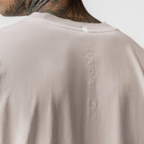 Tech Essential Relaxed Tee in Faded Chai, back view on model showing embroidered branding