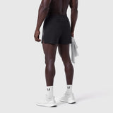 Aerotex 3" Distance Short in black, worn by model from behind, paired with white socks and sneakers