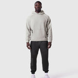 Tech-Terry Training Hoodie in heather grey worn with black joggers, front view