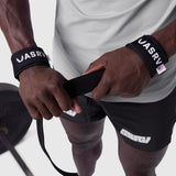 Padded Lifting Straps in black worn on wrists, held around exercise equipment