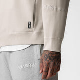 Tech Essential Distressed Crewneck in Faded Stone, worn with grey joggers, detail view