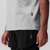Tech Essential Relaxed Tee in heather grey worn by model, side view showing fit and length
