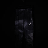 SM'20 Cargo High Rib pants in black with reflective logo, displayed on model against dark background
