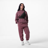 Tech Essential Distressed Hoodie in faded crimson, worn with matching joggers and black waist bag