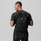 Antibacterial Mesh Drawstring Bag in black, worn on model's back over t-shirt