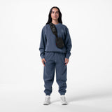 Tech Essential™ Sweats in faded navy, worn with black shoulder bag and white sneakers