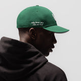 New Era 59Fifty Low Profile Hat in emerald green with white wings logo, worn by model in profile view