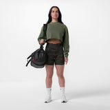 Tech Essential Relaxed Long Sleeve in faded olive worn with black shorts, model holding black backpack