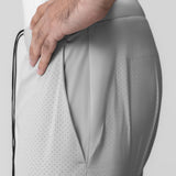Slate grey 7" liner short with perforated fabric, worn with hand touching hip pocket detail