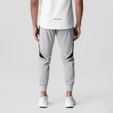 Slate grey cuffed training jogger with black side panels, back view on model