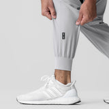 Slate grey cuffed training jogger worn with white sneakers, front view detail