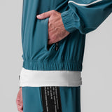 Aerotex Track Jacket in storm blue with white stripe, worn by model showing side pocket detail