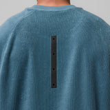 Towel Terry Cutoff in storm blue, back view with black button detail on model