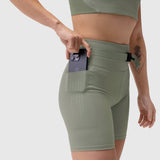 Lycra 3-in-1 Biker Short in sage, model wearing and retrieving phone from pocket