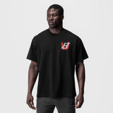 Black Tech Essential Relaxed Tee with red neon logo, worn by model, front view