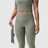 W030 Lycra 3-in-1 Legging in sage worn by model holding detachable pouch, front view