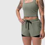 Tetra-Lite Liner Short in sage worn by model, front view with black underlay shorts