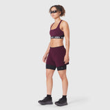 W083 LYCRA® ADAPTIV Racerback Sports Bra in Merlot, worn by model with matching shorts
